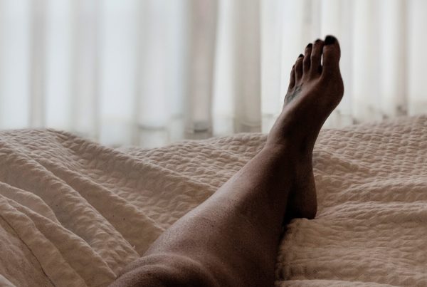 leg in bed with beige blanket